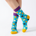 Colorful polka dot socks with purple cuffs on a white background