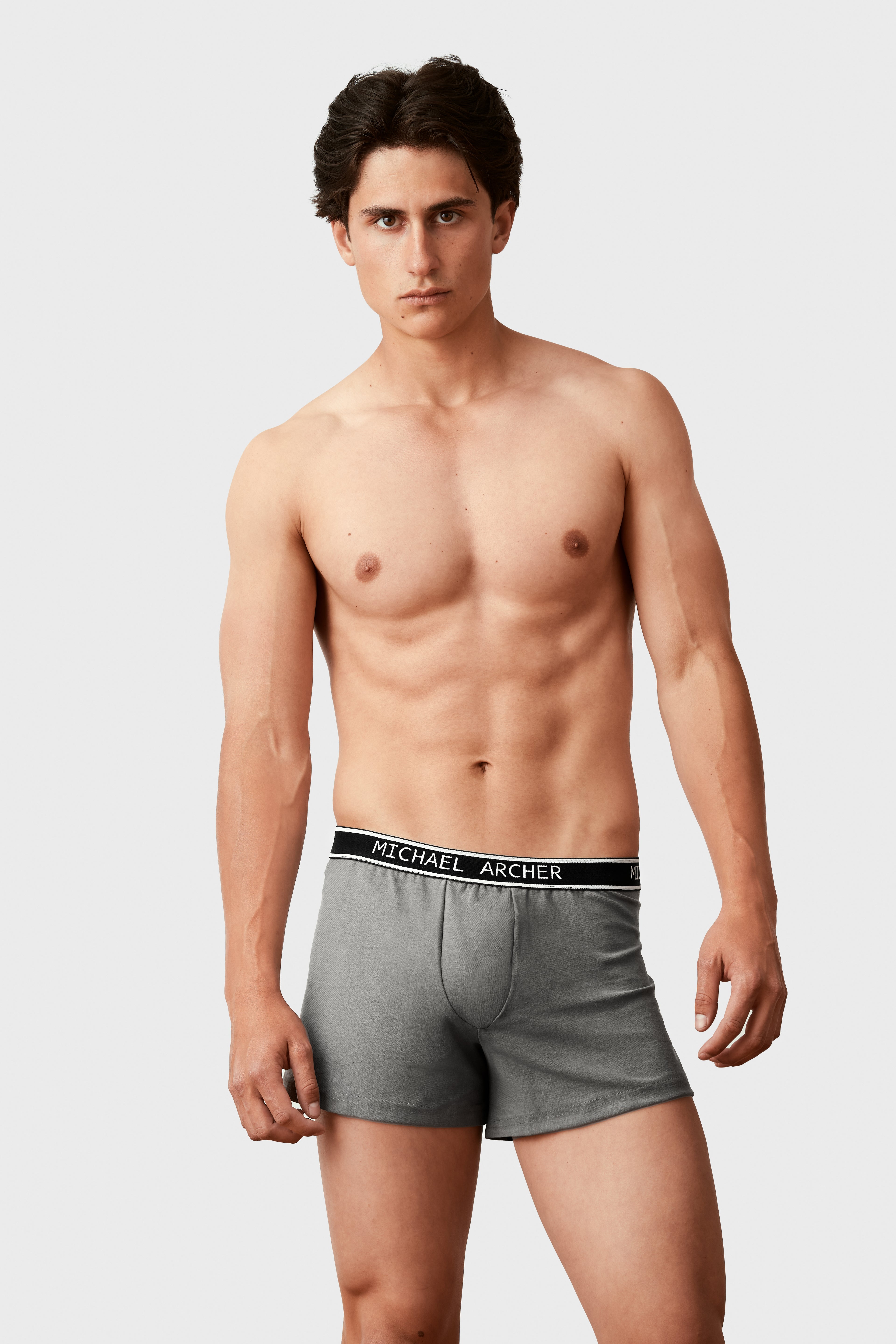 Man wearing gray underwear with a brand label on a white background