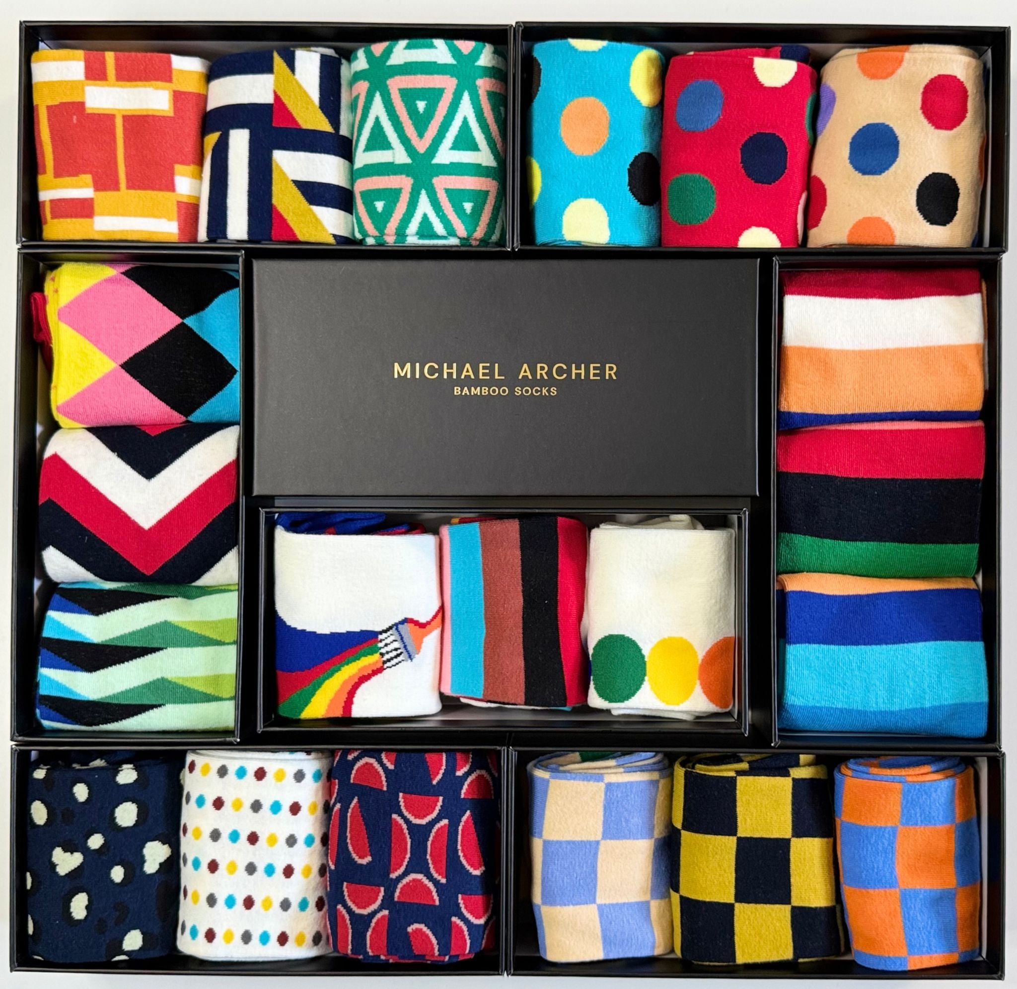 Assorted colorful socks in a 'Michael Archer' box