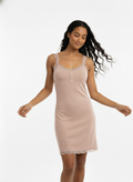 Woman wearing a beige nightgown on a white background
