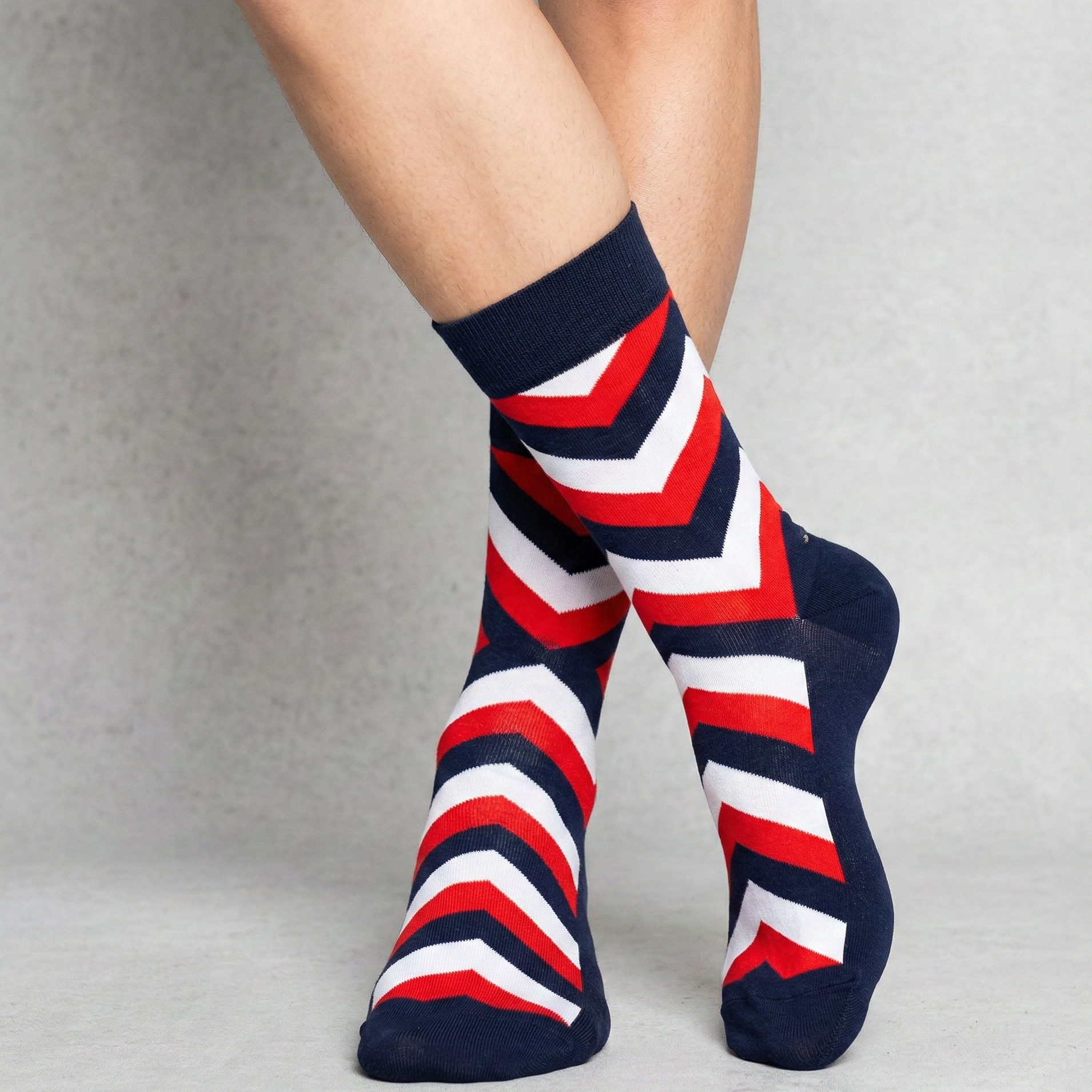 Red, white, and blue striped socks on a neutral background
