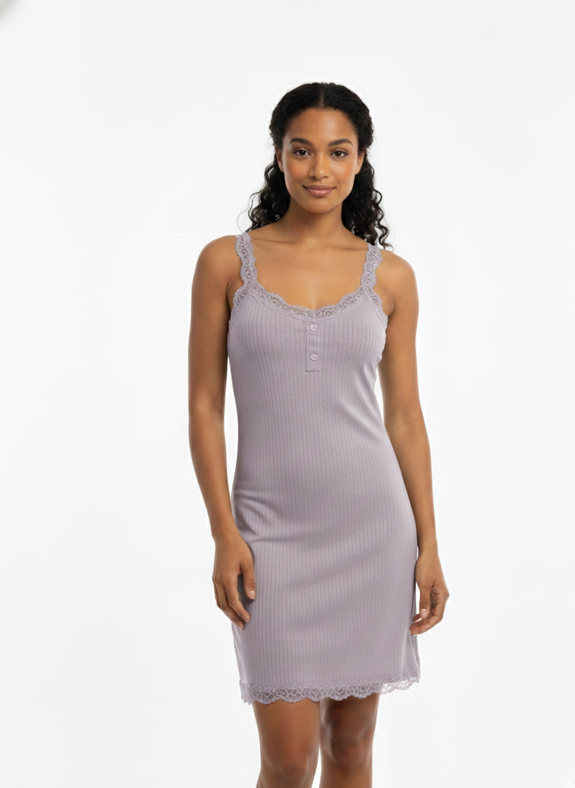 Woman wearing a light purple nightgown with lace trim on a white background